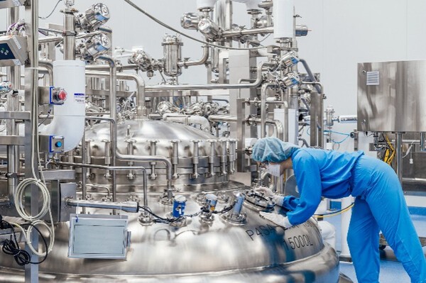  '삼성바이오로직스 송도 생산라인에서 직원이 항체의약품 배양 공정을 점검하고 있는 모습. ' / 삼성바이오로직스 송도 캠퍼스 내 5,000L 규모 스테인리스 발효기(바이오리액터) 장비에서 엔지니어가 품질 검증 및 공정 모니터링을 수행하는 장면. 이는 상업용 항체의약품 대량생산 공정의 핵심 장비 중 하나다. (=삼성바이오로직스 ,CRO서비스제공)